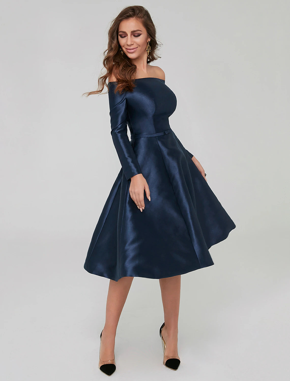 Side view of a woman wearing a long-sleeve off-shoulder party dress.