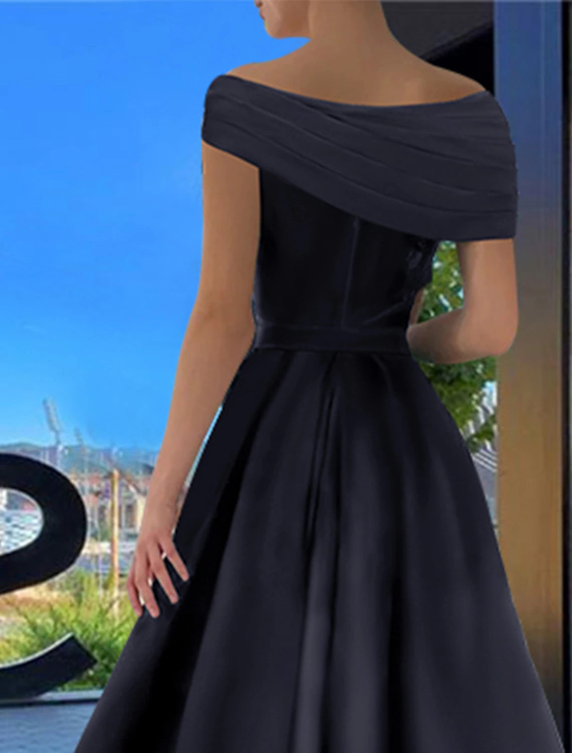 Full-length view of a woman wearing the black off-shoulder satin prom dress with a high slit.