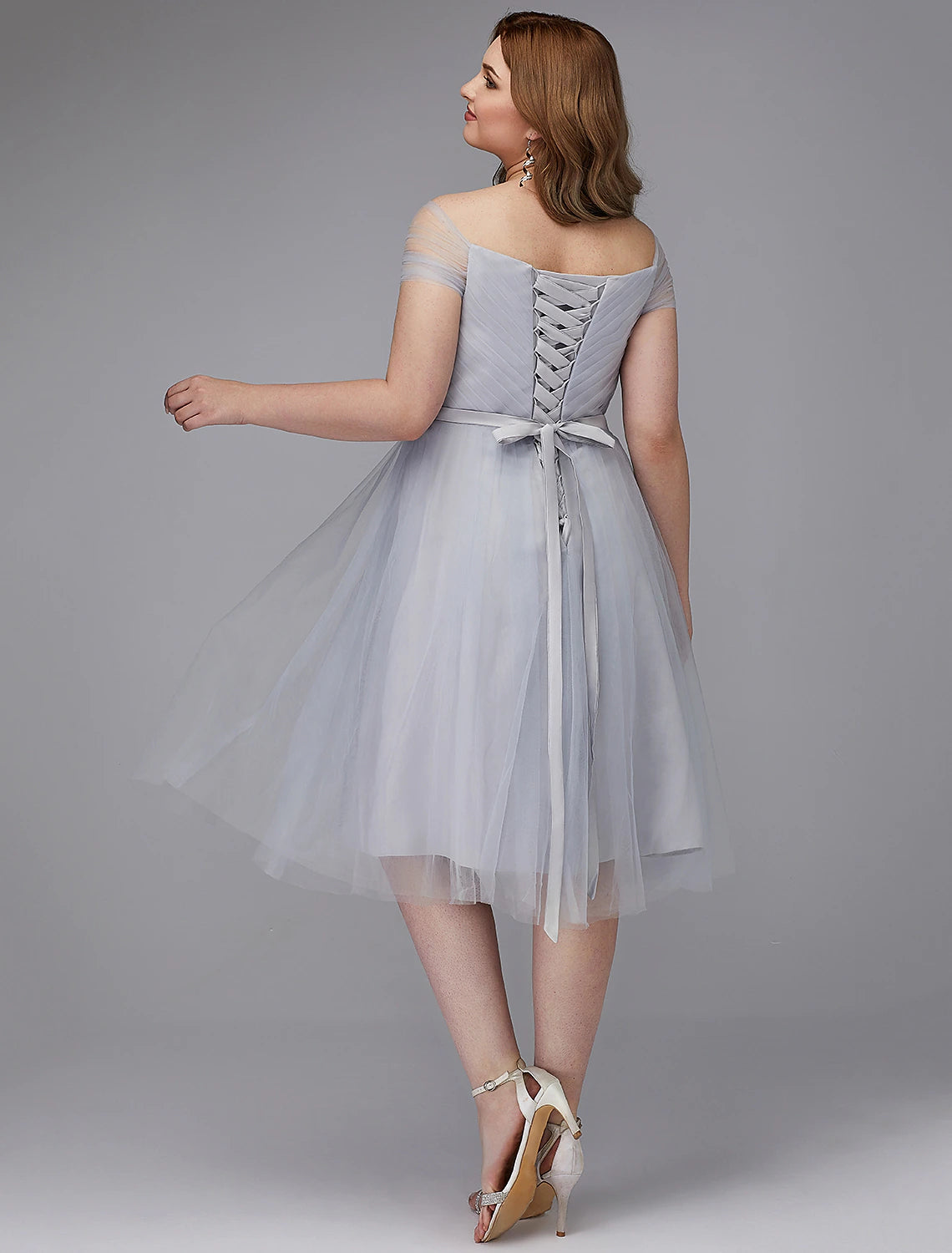 Side view of the elegant off-shoulder A-line tulle dress, showing the short sleeves and tea length.