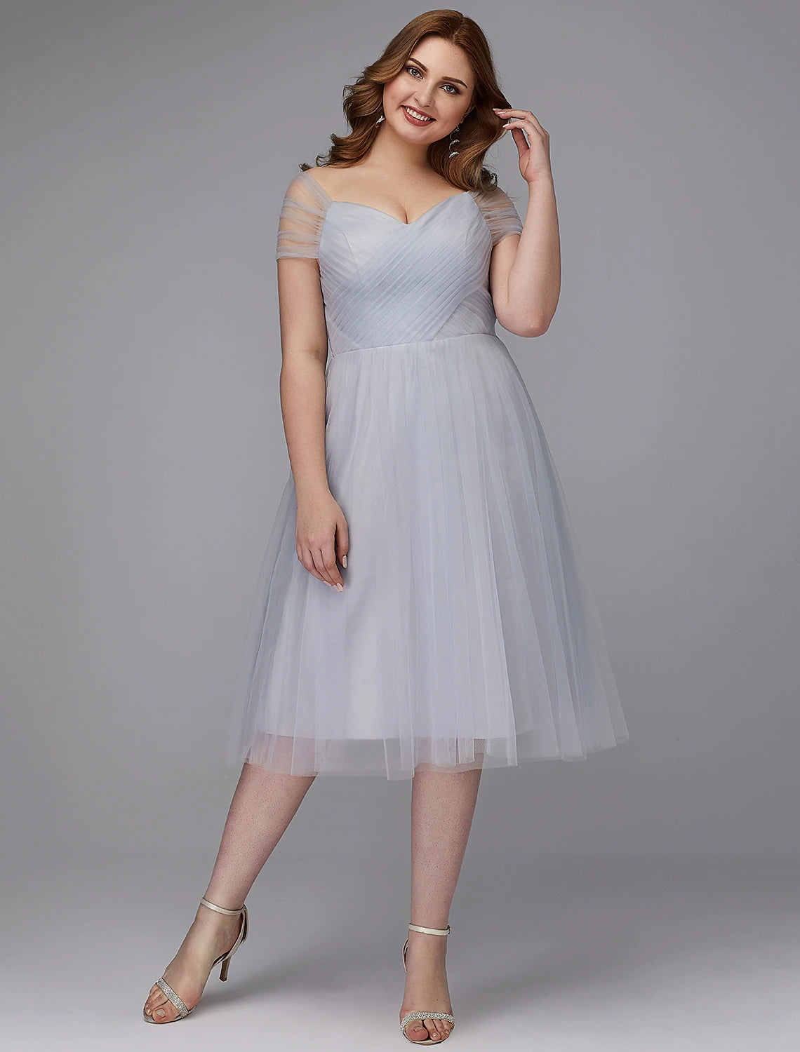 Full length view of the elegant A-line tulle dress, showcasing its flow and tea length.