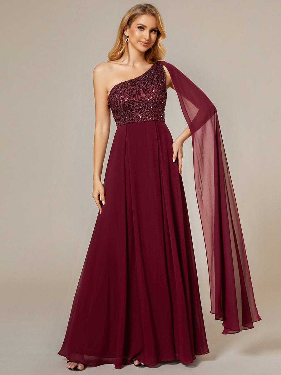 Model wearing a red one-shoulder A-line evening dress with a sequin bodice.