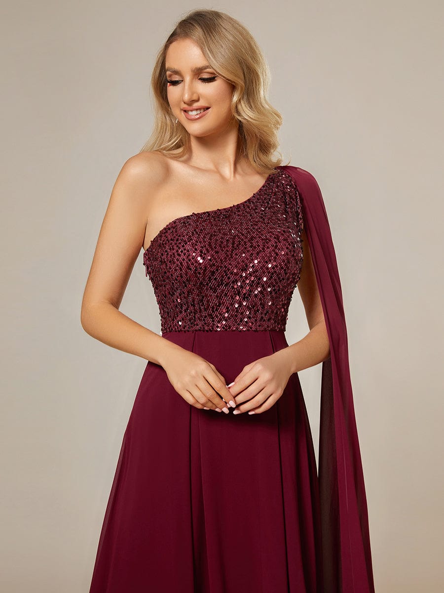Close-up of the shiny sequin bodice on a red one-shoulder evening dress.