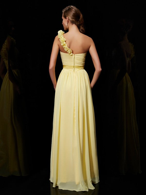 Back view of a woman in a one-shoulder chiffon bridesmaid dress.
