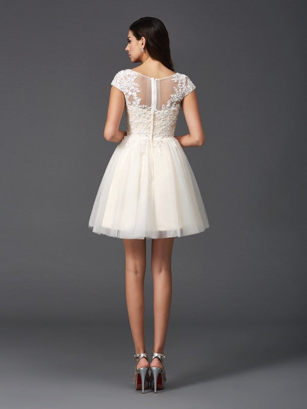 Back view of the A-line princess short net dress with delicate appliques.