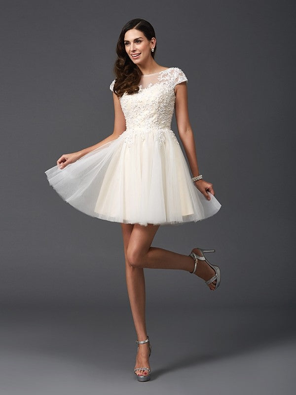 Close-up of the applique details on the short net party dress.
