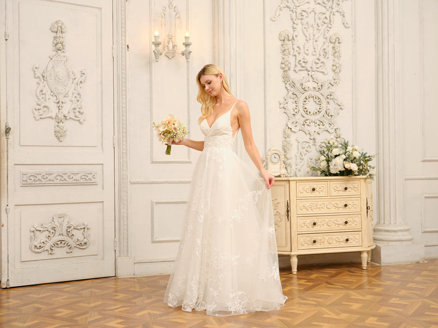 Close-up of the V-neck bodice and intricate appliques on the white wedding dress.