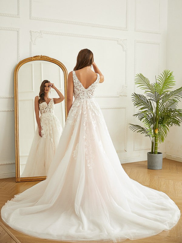 Close-up of the V-neck bodice with intricate floral applique on the wedding dress.