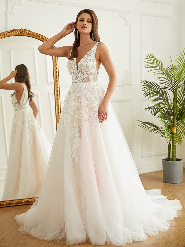 Back view of the wedding dress, highlighting the flowing chapel train and delicate fabric.
