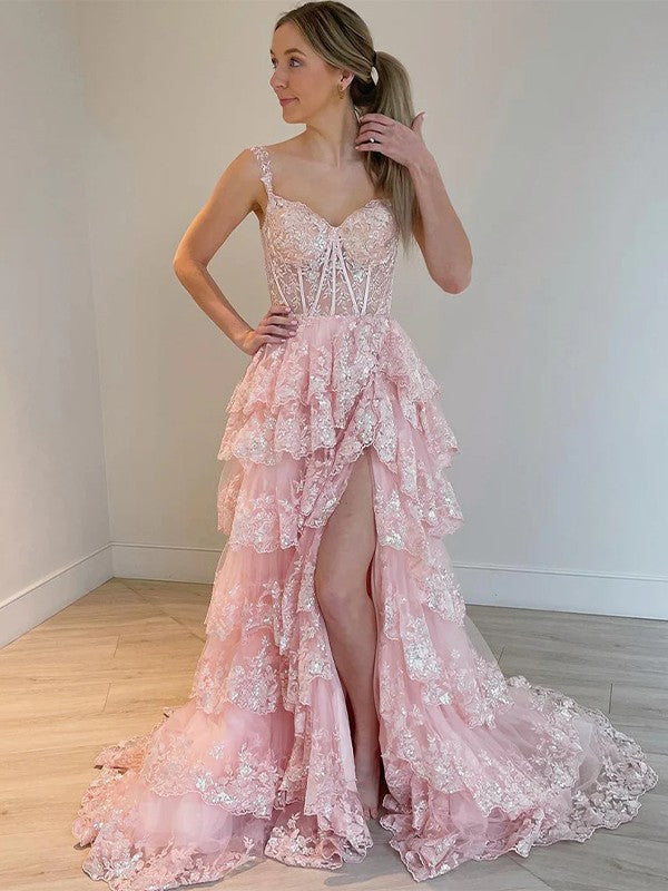 Woman wearing an elegant A-Line Princess tulle prom dress with delicate lace straps and a flowing court train.