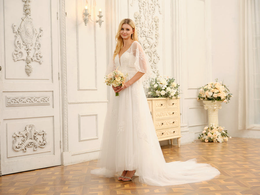 Close-up of the V-neckline, half sleeves, and intricate appliques on the wedding dress bodice.