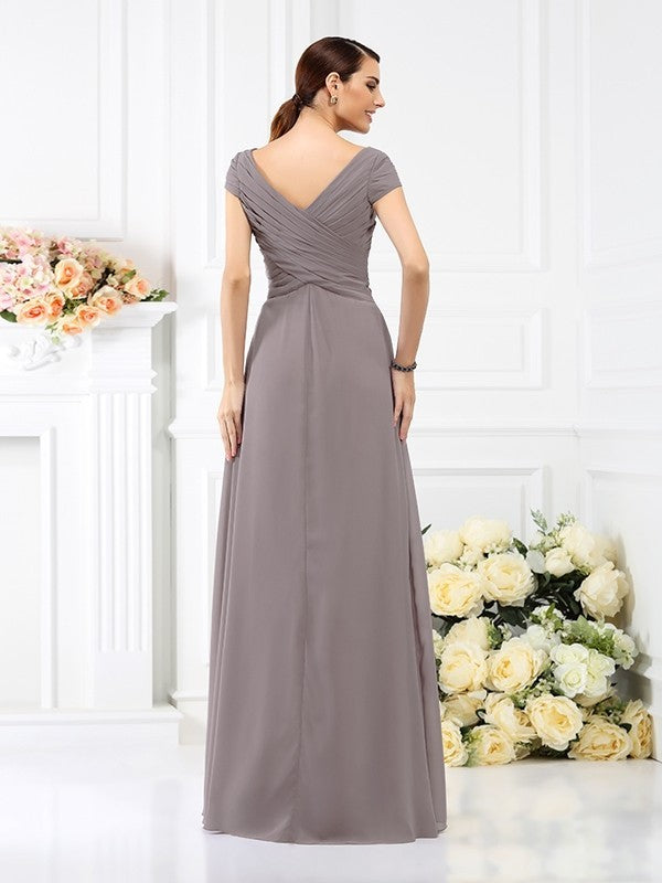 Back view of a woman wearing a long chiffon bridesmaid dress with short sleeves.