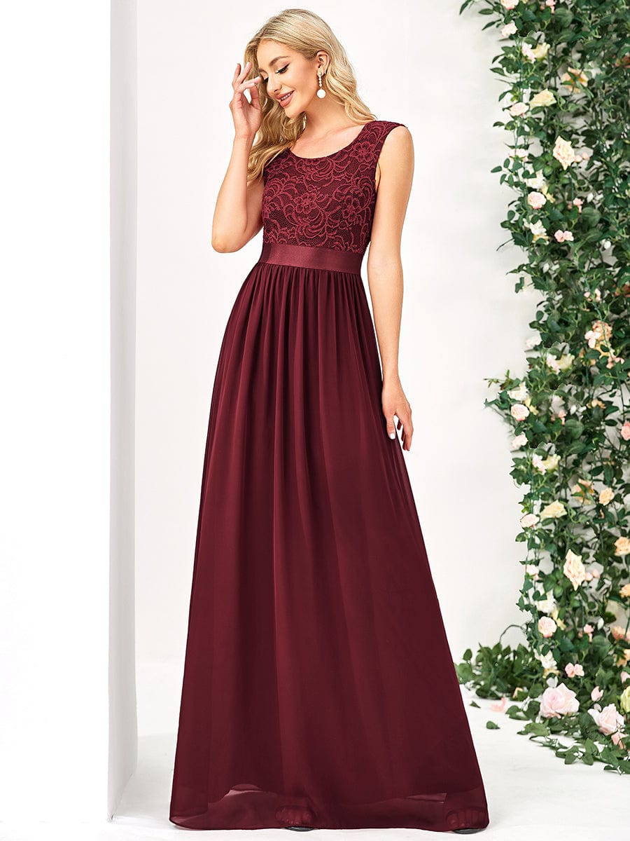 Model in a blue A-line bridesmaid dress with a round neck and lace bodice.