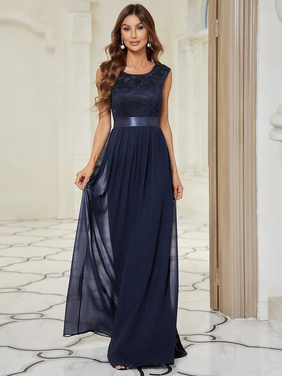 Model in a navy A-line bridesmaid dress with a round neck and lace bodice.