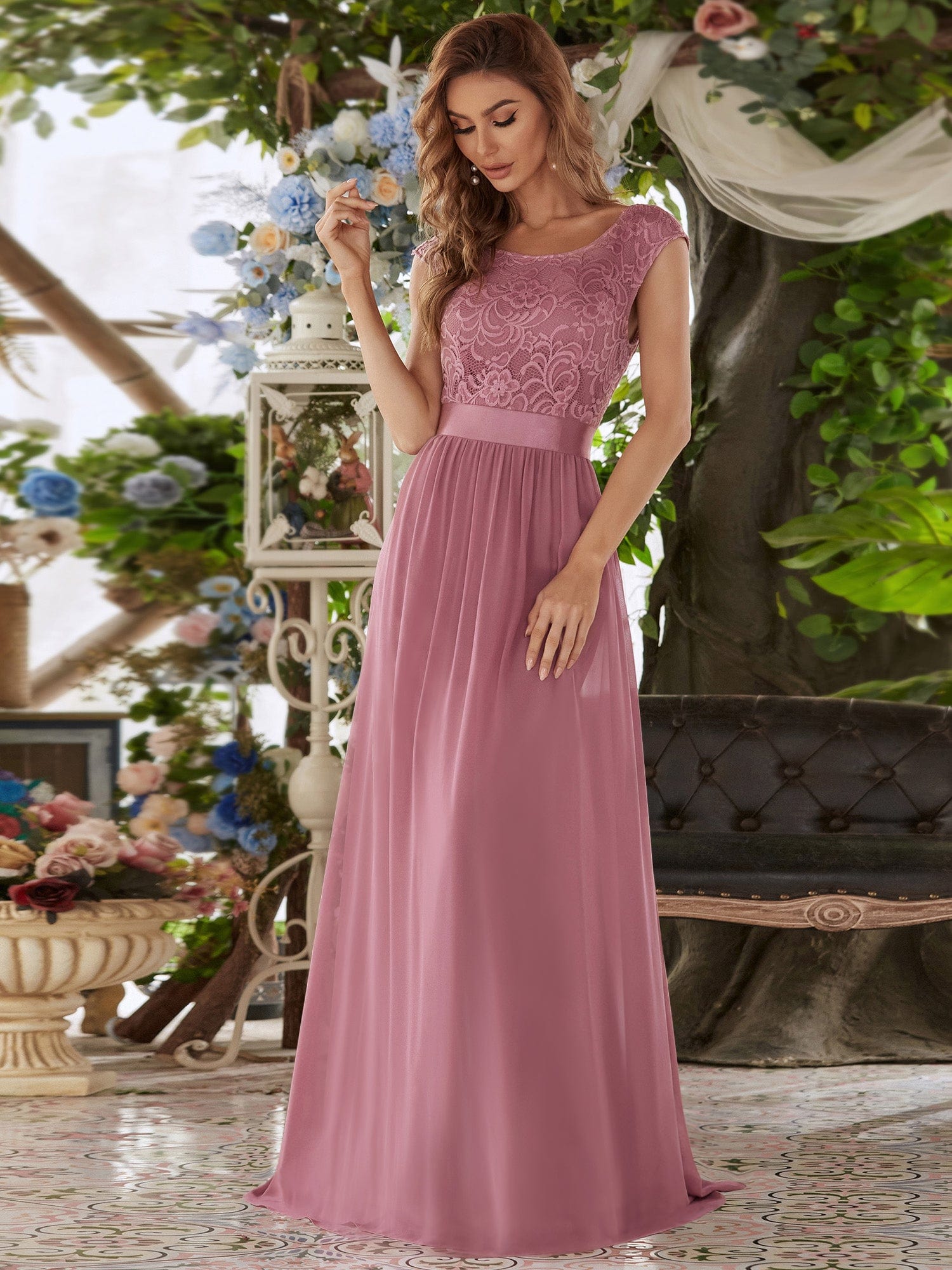 Full length view of a model in an olive green A-line bridesmaid dress, showcasing the flowy skirt.