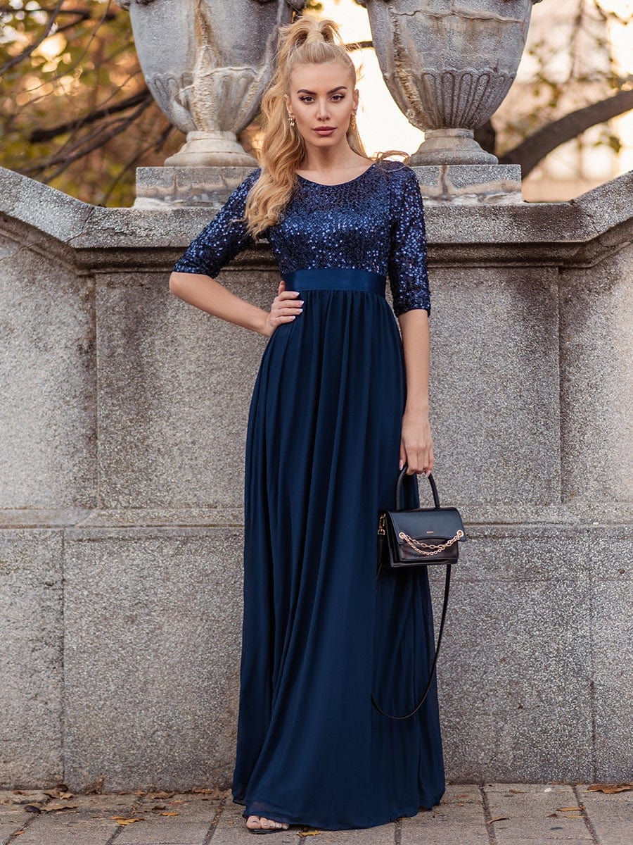 Woman in a navy blue long sleeve sequin evening dress.