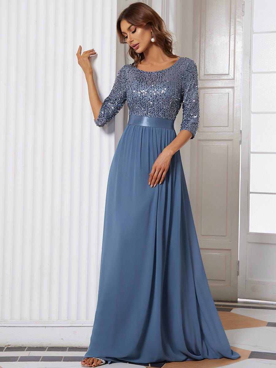 Woman in a dark blue long sleeve sequin evening dress.