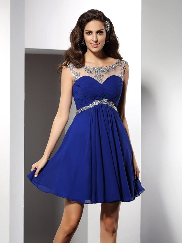 Model wearing a light blue A-line short cocktail dress with scoop neck and delicate beading.