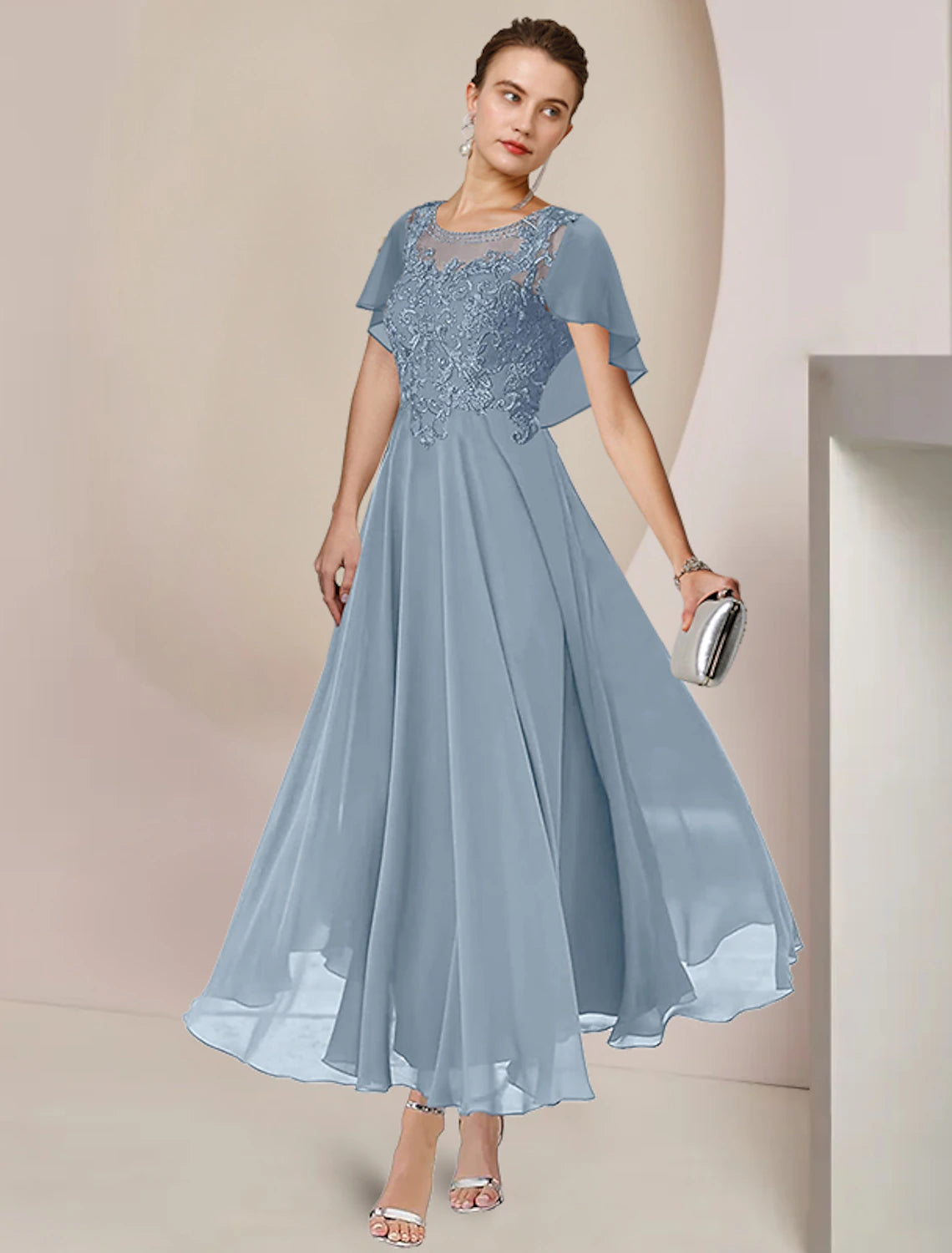 Woman wearing an elegant A-line scoop neck tea-length mother of the bride dress with lace and beading.