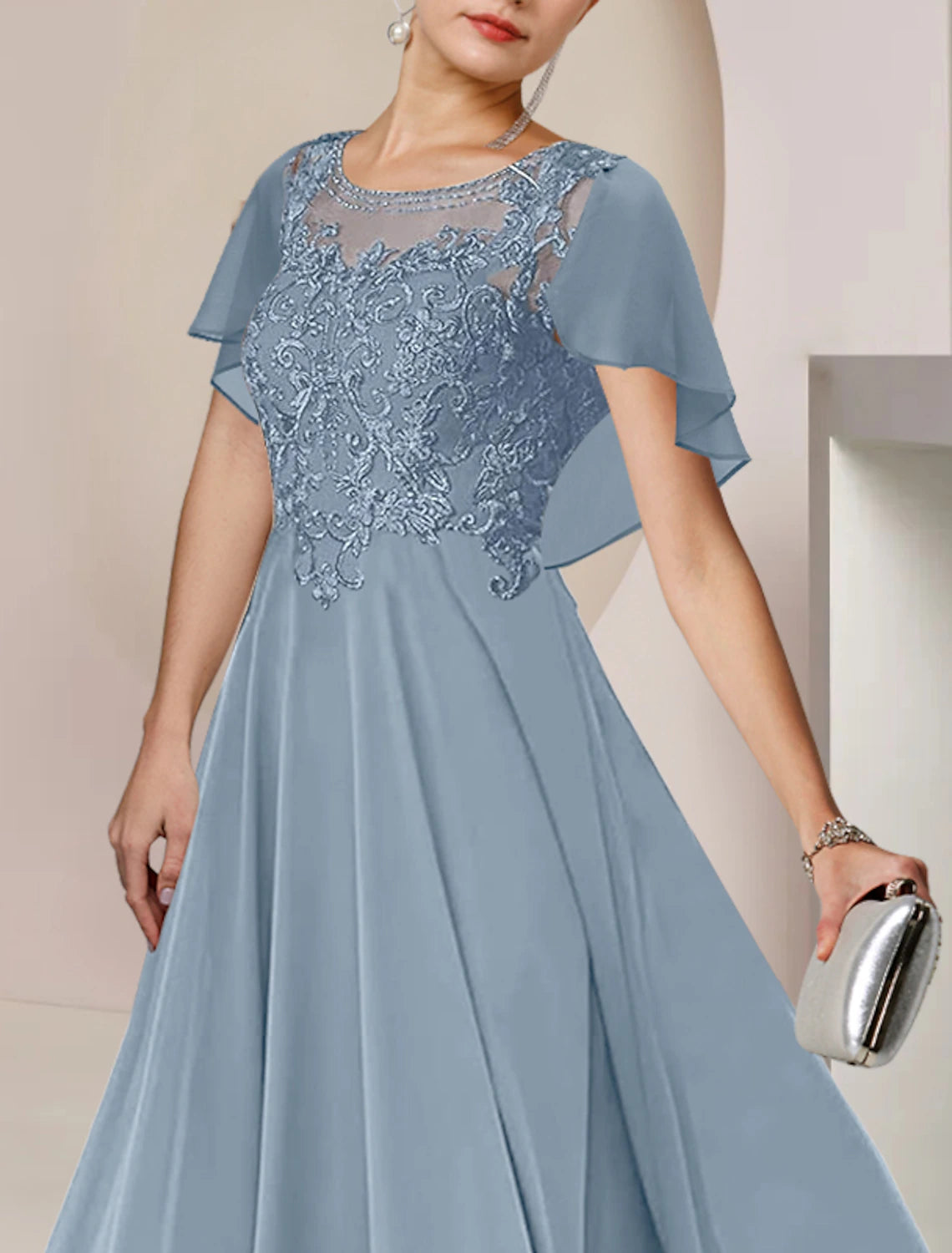 Close-up of the scoop neck and intricate lace and beading details on the dress.