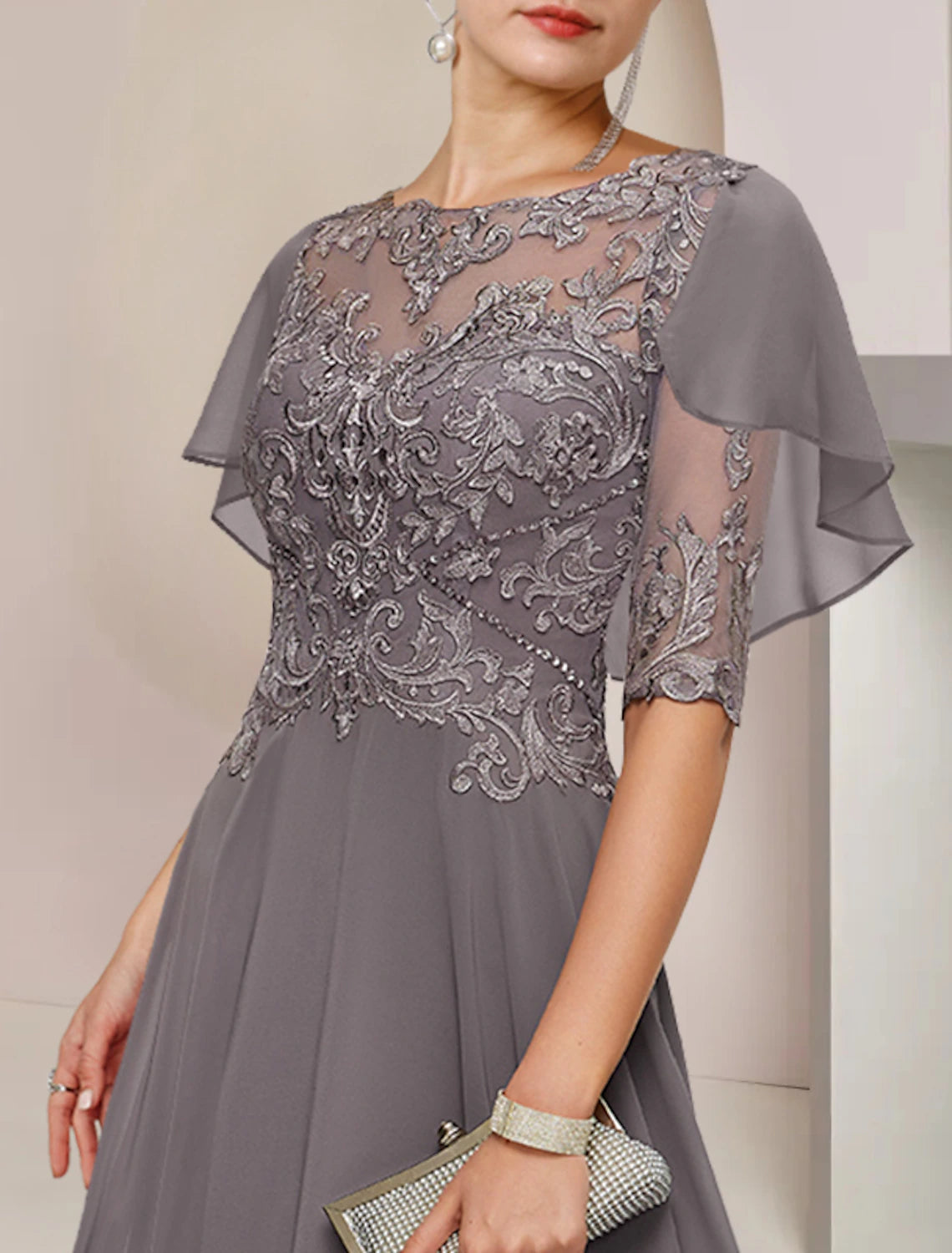 Close-up of the scoop neck and half sleeve of the chiffon lace dress with beading appliques.