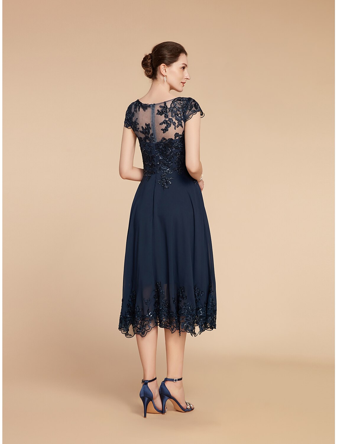 Close-up of the delicate lace and sequin appliques on the dress sleeve.