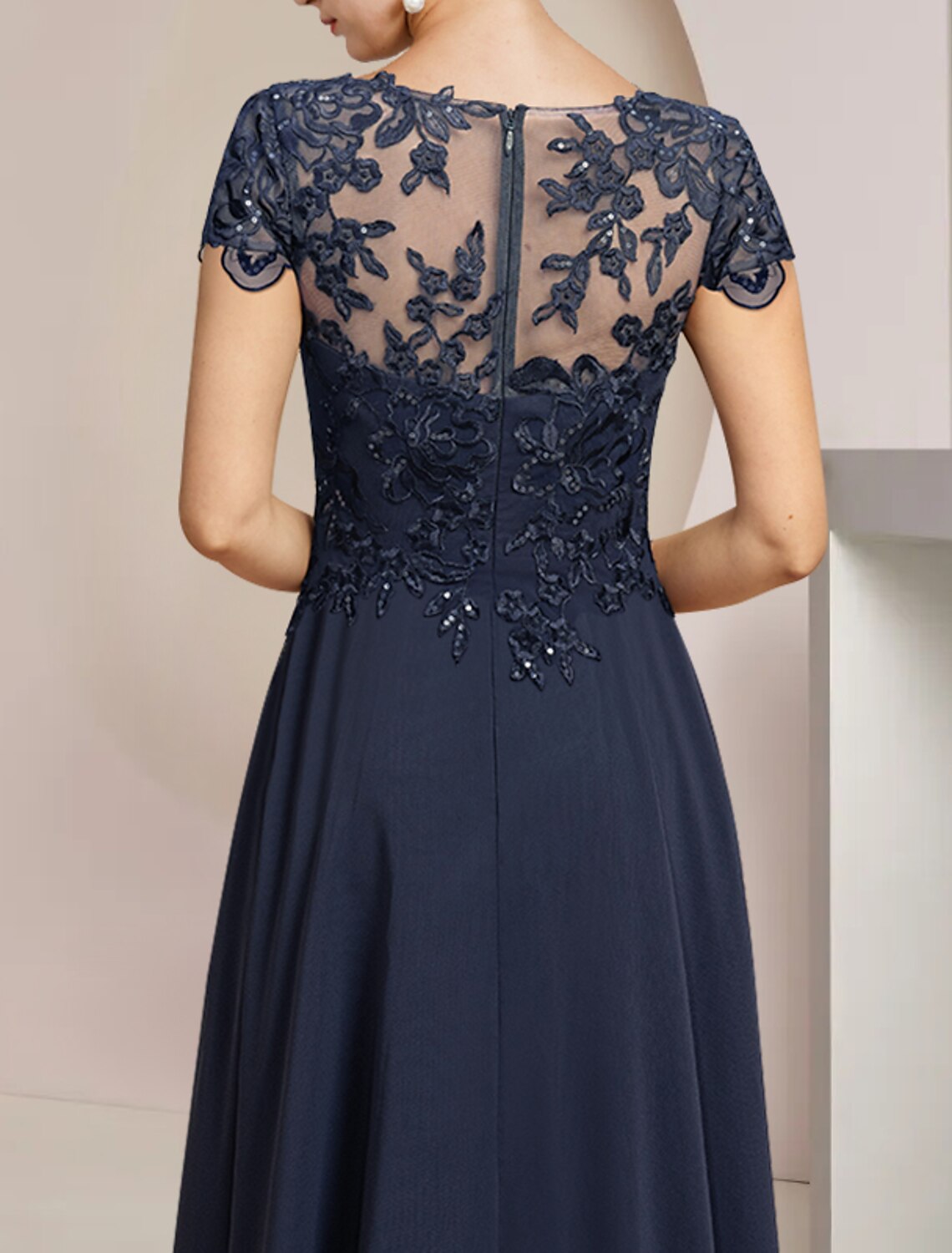 Close-up of sequin appliques and lace detail on the dress fabric.