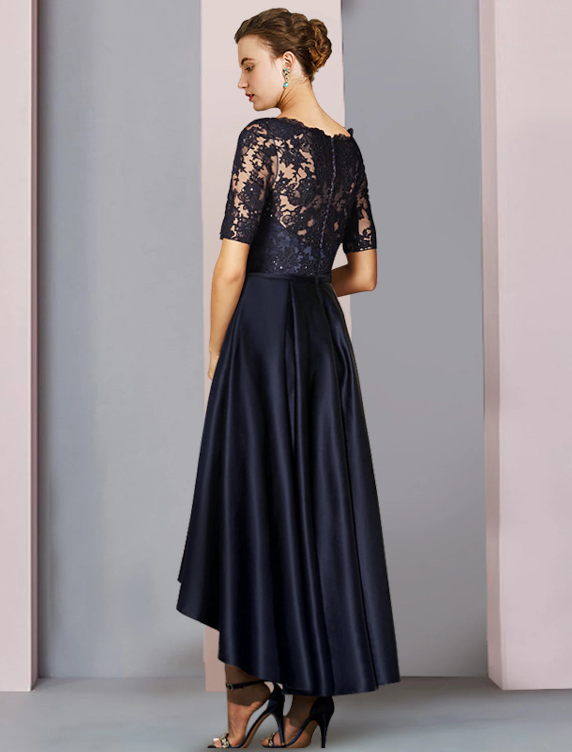 Woman wearing an elegant A-Line high-low tea length Mother of the Bride dress.