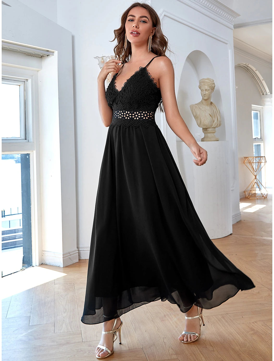 Back view of a woman in a flowing chiffon evening dress with sequin embellishments.