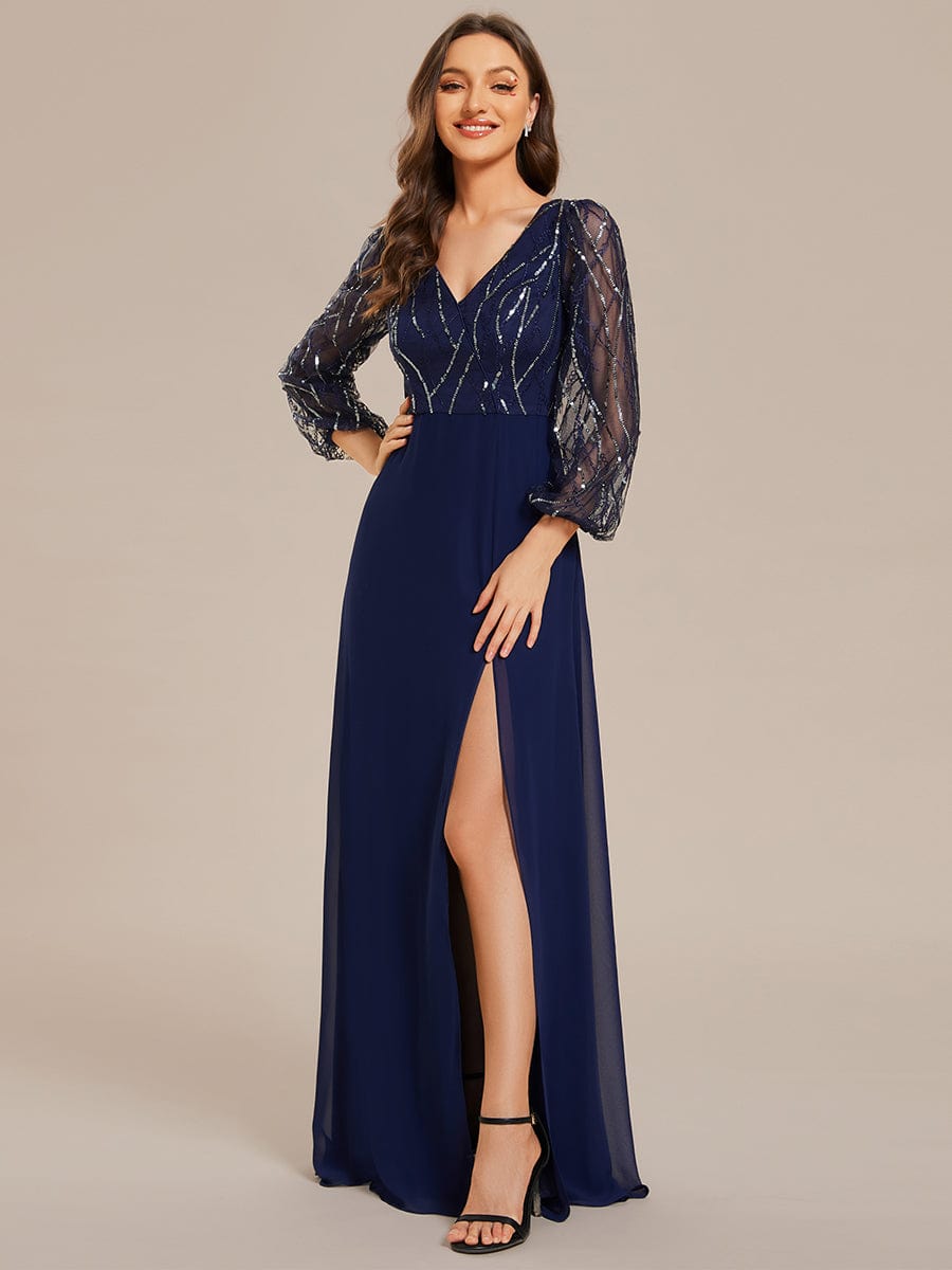 Model wearing a navy blue sequin and chiffon A-line evening dress with long sleeves and a high slit, front view.