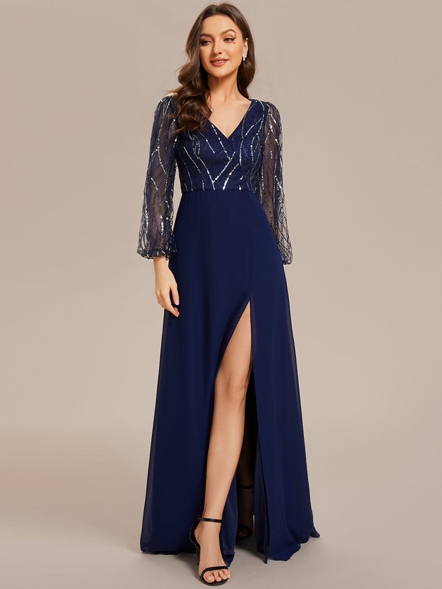 Model wearing a navy blue sequin and chiffon A-line evening dress with long sleeves and a high slit, close-up of bodice.