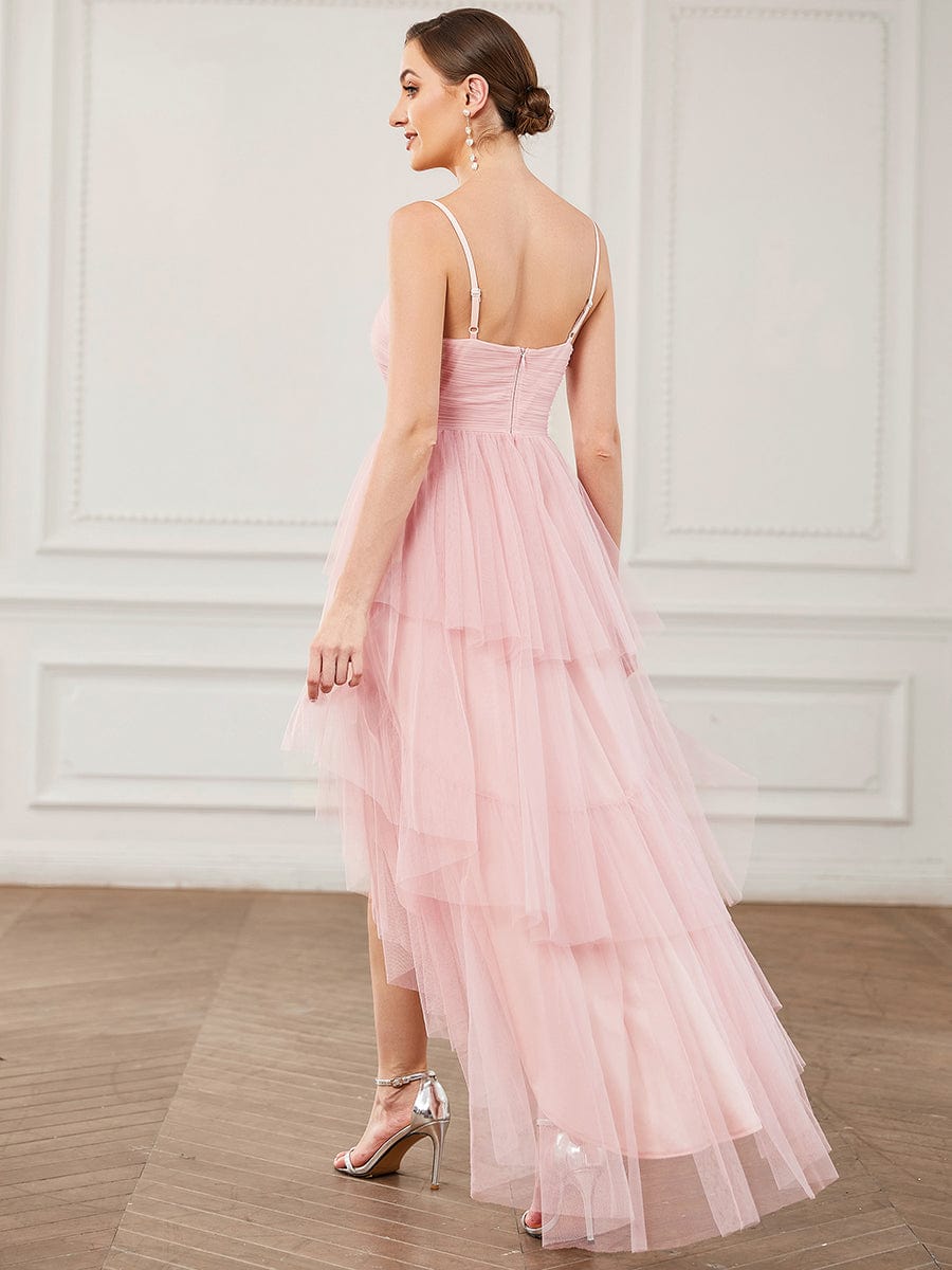 Side view of a woman in a ruffled high-low tulle bridesmaid dress.