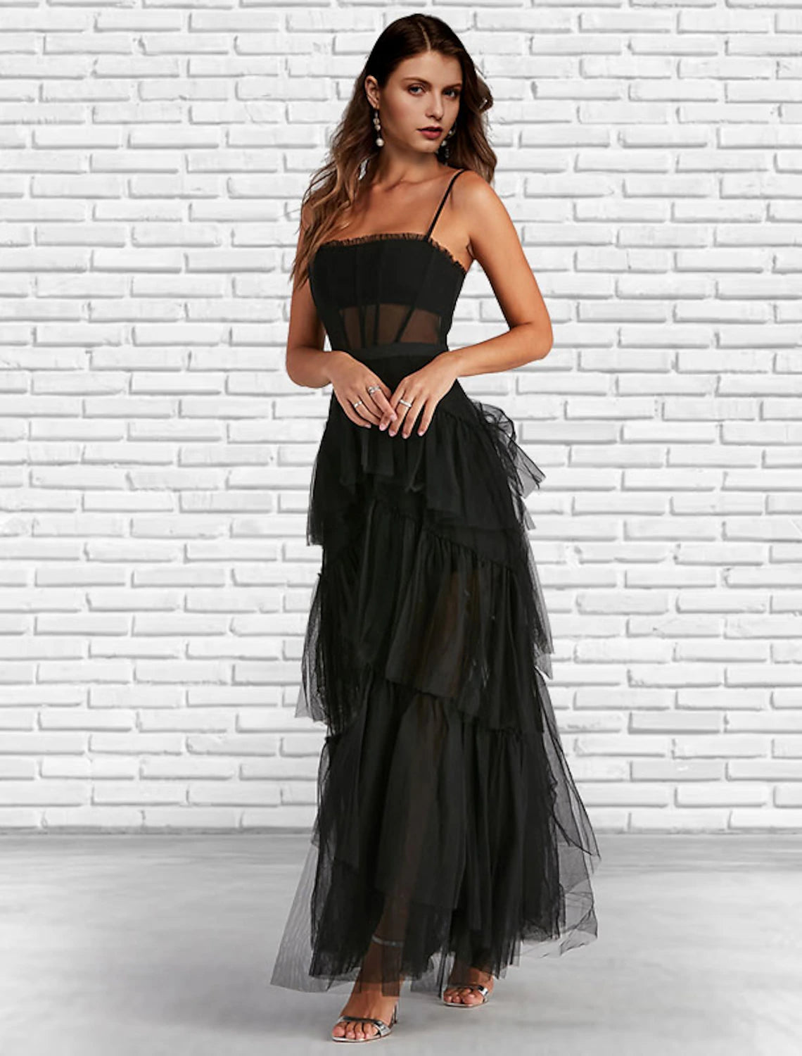 Model wearing a strapless A-line tulle prom dress with ruffles and a ladder back.