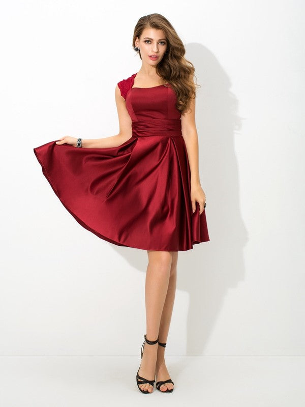 Model wearing an elegant A-Line short satin bridesmaid dress with straps and pleats.
