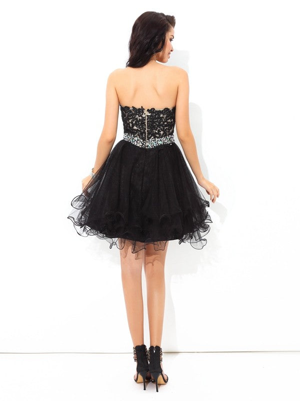 Close-up of the delicate applique detail on the sweetheart neckline of the satin dress.