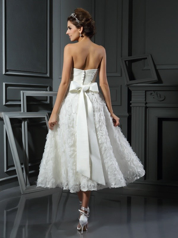 Back view of a bride in a white short lace wedding dress with bowknot detail.