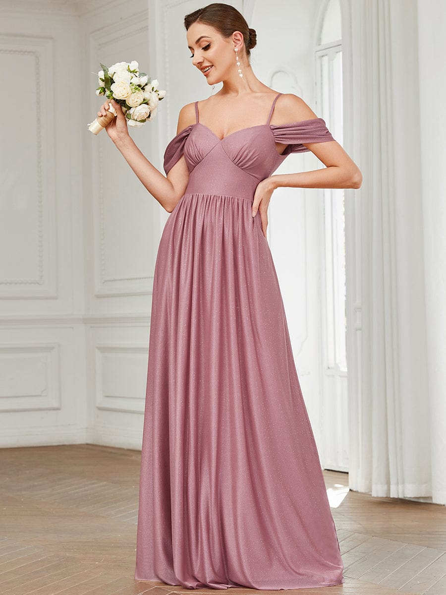 Side view of a model in a rust-colored draped sleeve cold shoulder bridesmaid dress.