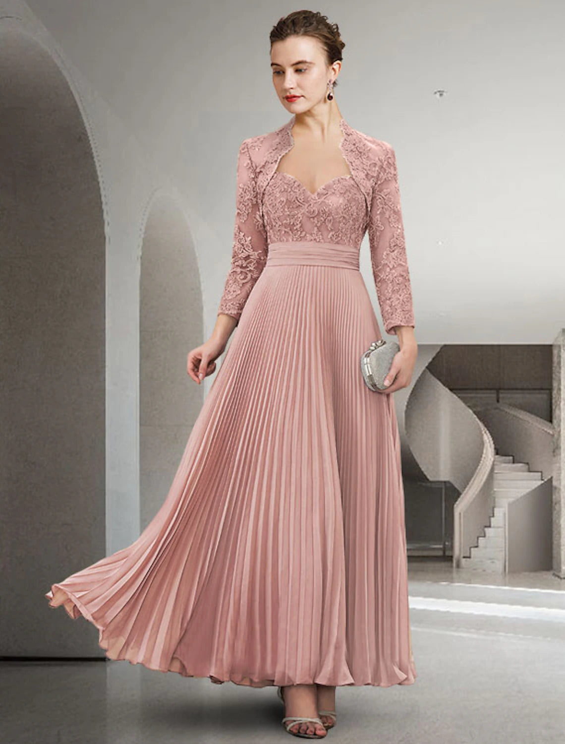 Woman wearing an elegant two-piece A-line mother of the bride dress with a sweetheart neckline and long sleeve lace jacket.