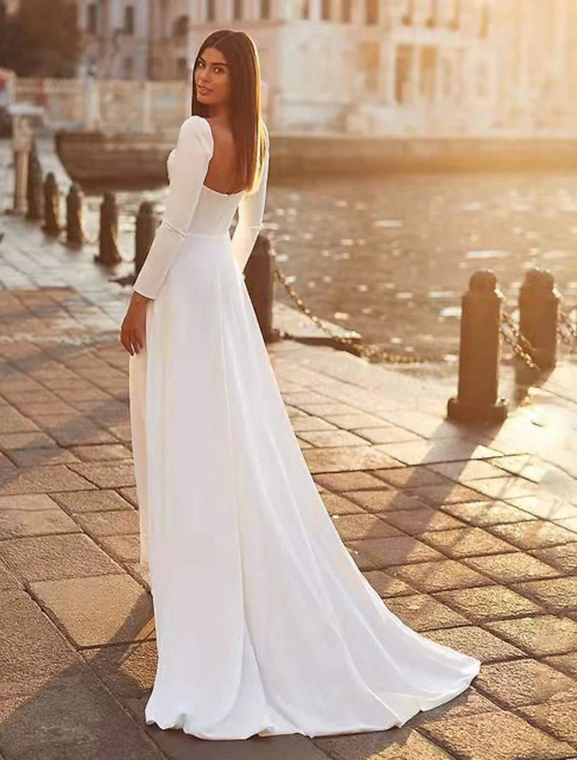 Side view of a woman in an A-line sweetheart long sleeve satin gown, showcasing the silhouette.