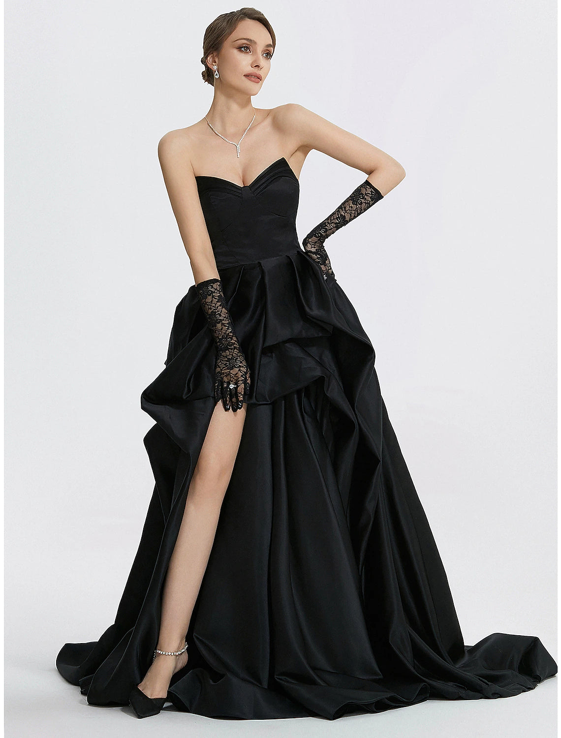 Close-up of the ruched slit detail on the satin evening gown.