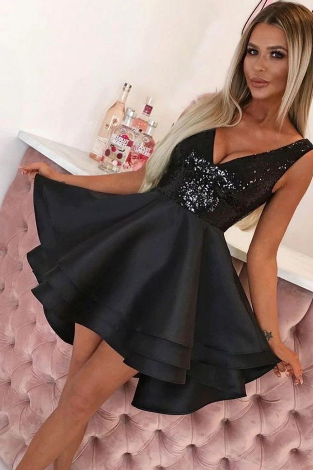 Back view of a model in a black A-line homecoming dress with a sequin top.