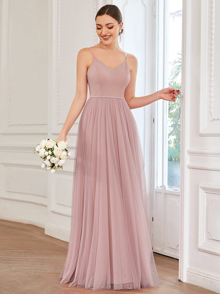 Model wearing an elegant red A-line tulle bridesmaid dress with a sweetheart neckline and spaghetti straps.