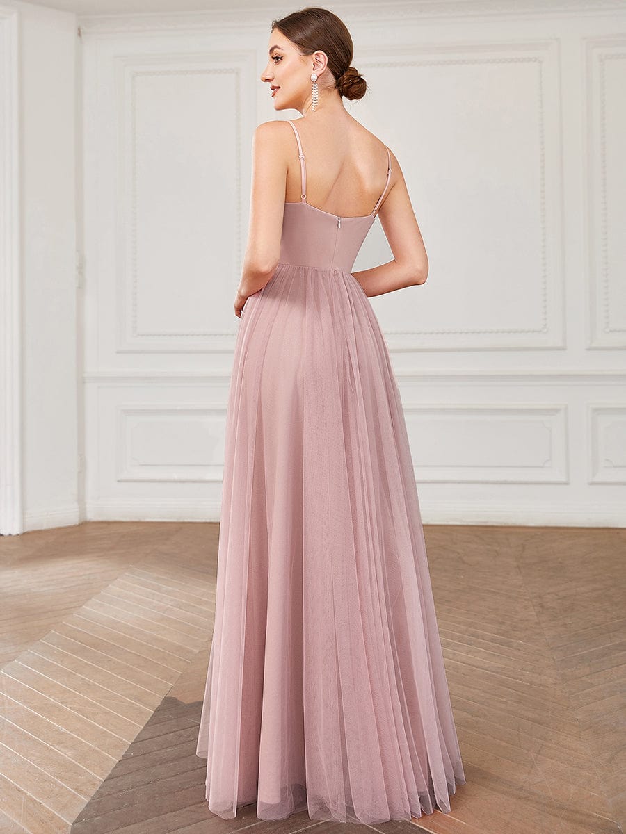 Back view of a model in a flowing red A-line tulle bridesmaid dress.