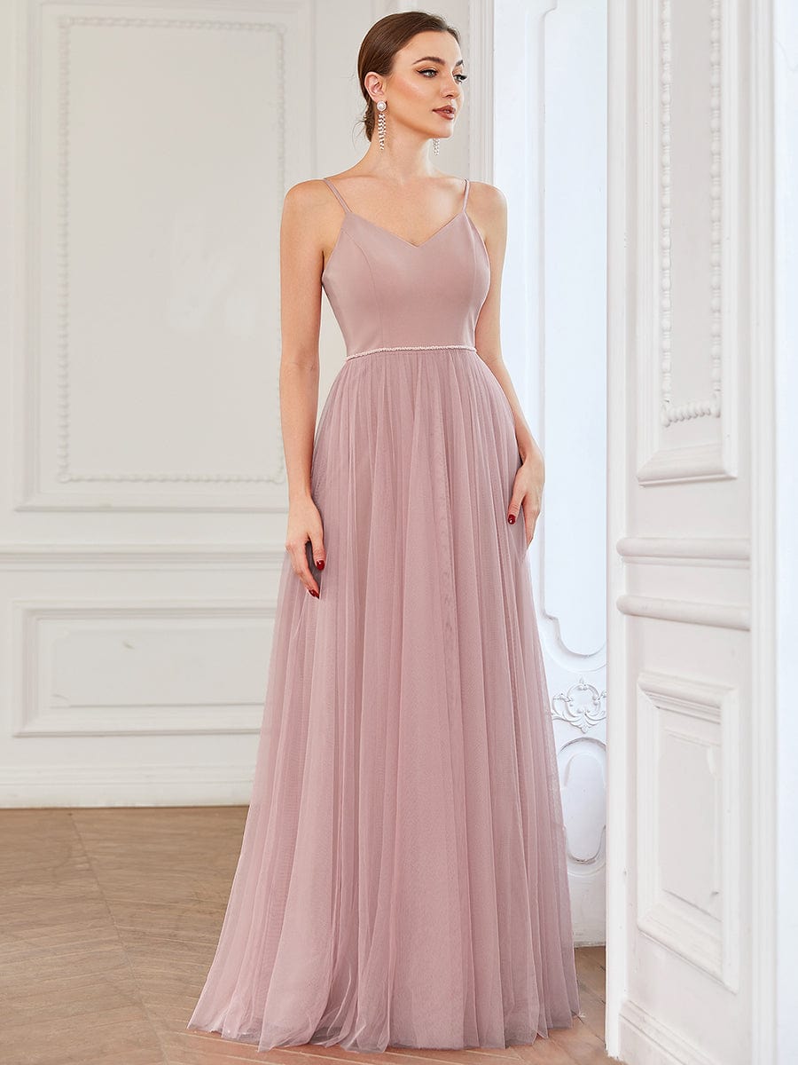 Full-length view of a model posing in a red A-line tulle bridesmaid dress.
