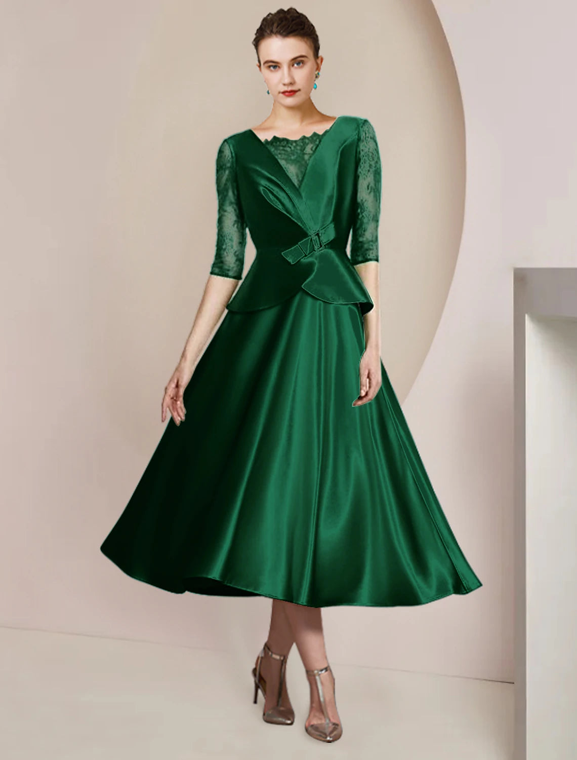 Woman wearing an elegant A-line tea-length dress with scoop neck and half sleeves.