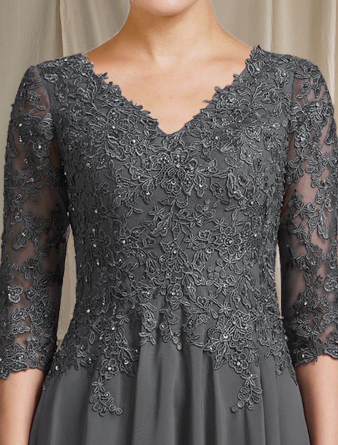 Close-up of the V-neck bodice and 3/4 lace sleeve details on the elegant gown.