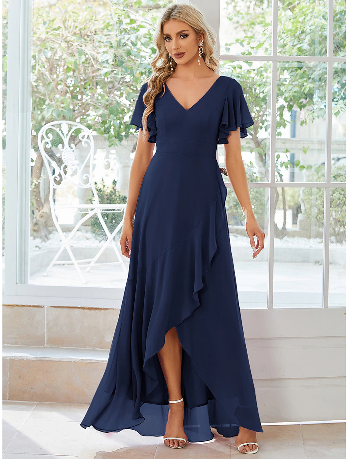 Model wearing a solid color A-line V-neck dress with asymmetrical short sleeves and ruffles.