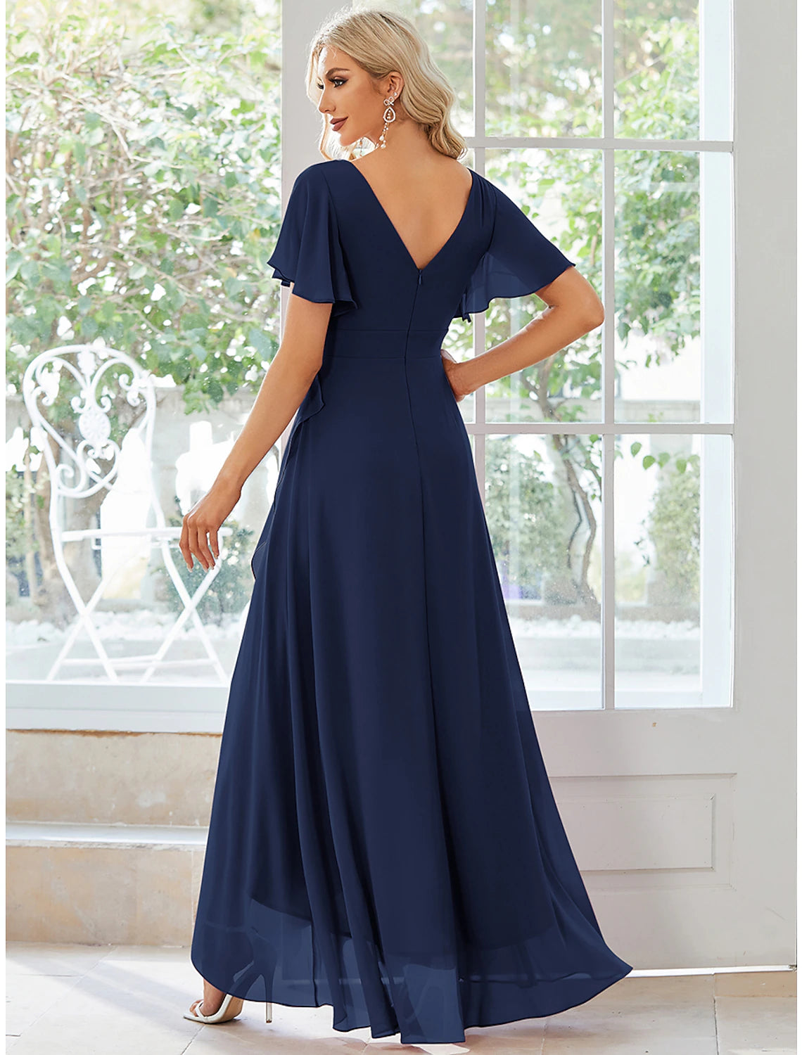 Model posing in a solid color chiffon A-line dress, showing the V-neck and ruffled asymmetrical sleeves.