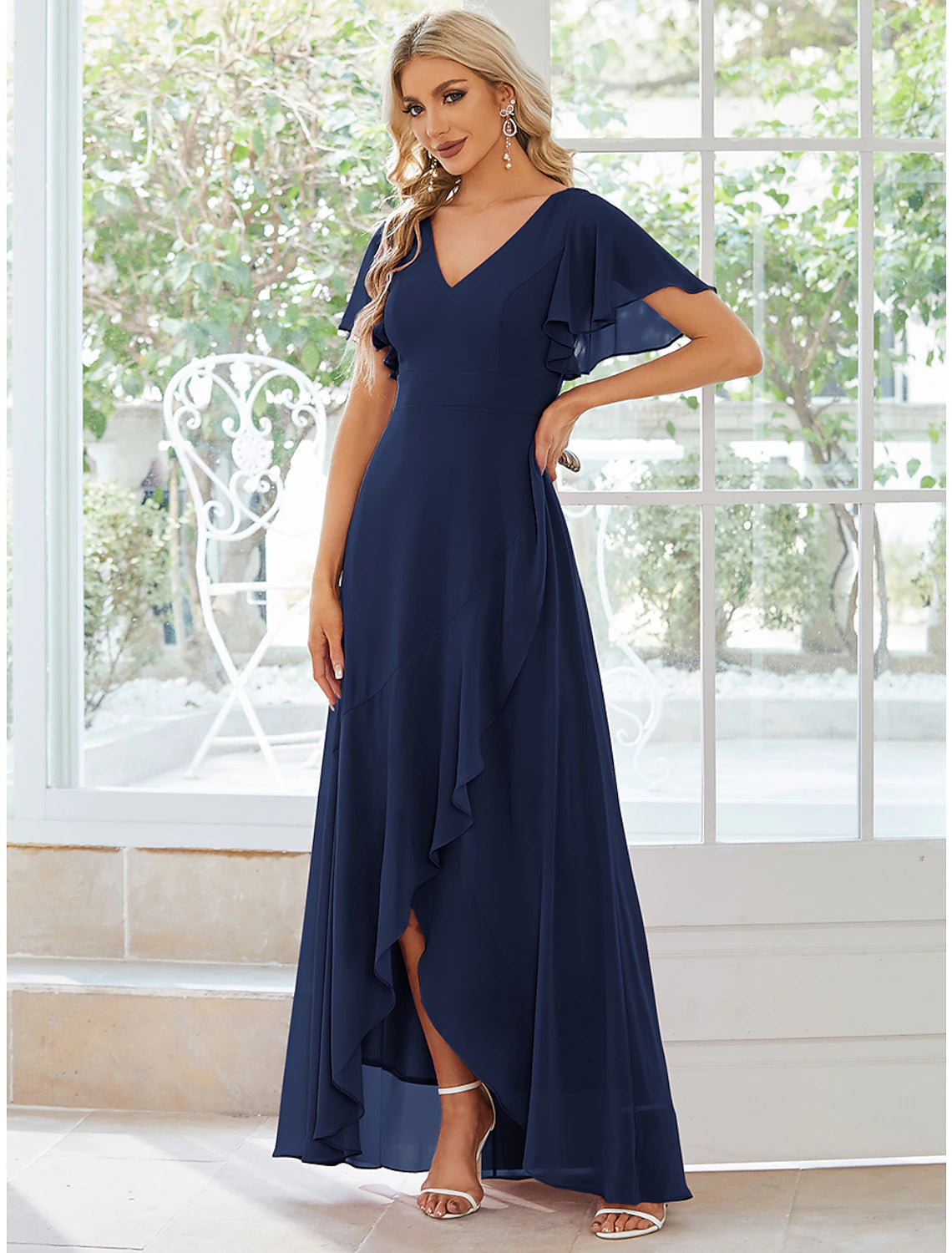 Close-up of the V-neck and ruffled asymmetrical short sleeve detail on the chiffon dress.