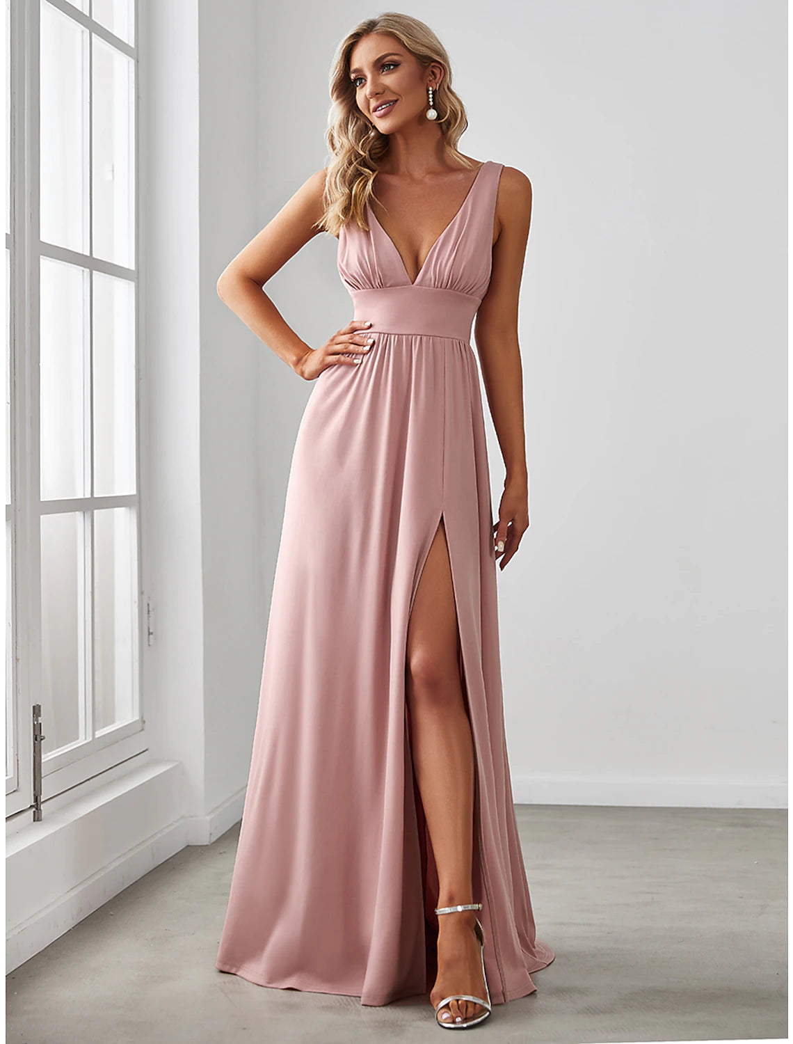 Woman wearing an elegant A-line V-neck chiffon gown with a high slit.