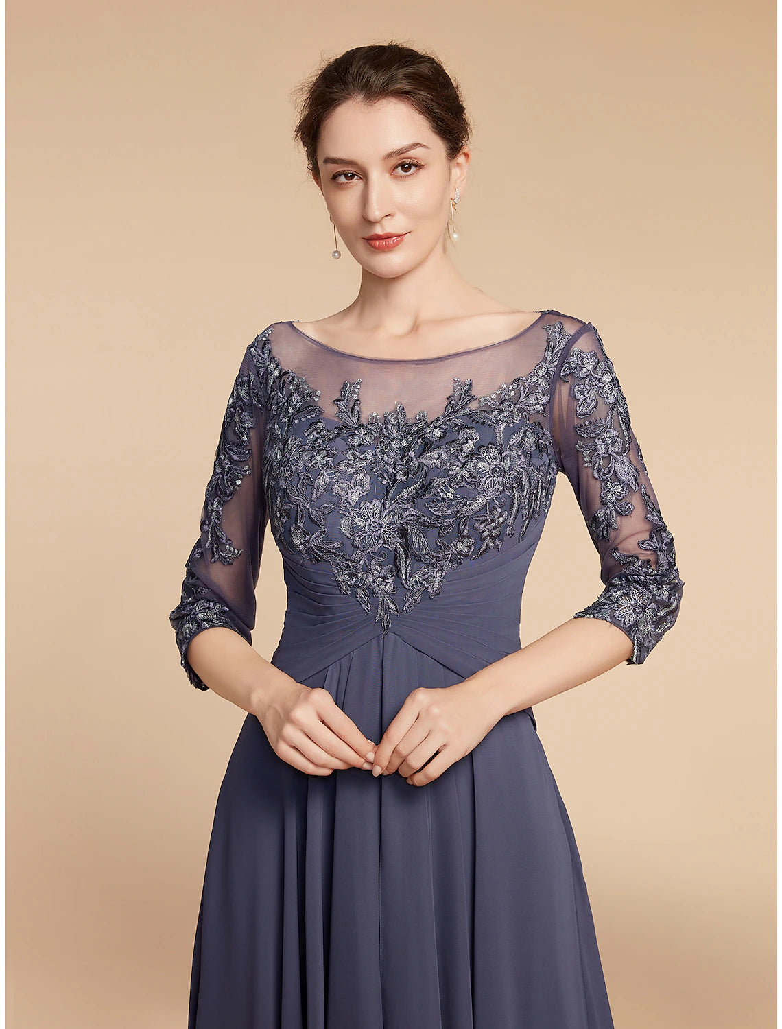 Close-up of the V-neckline and lace appliques on the elegant mother of the bride gown.